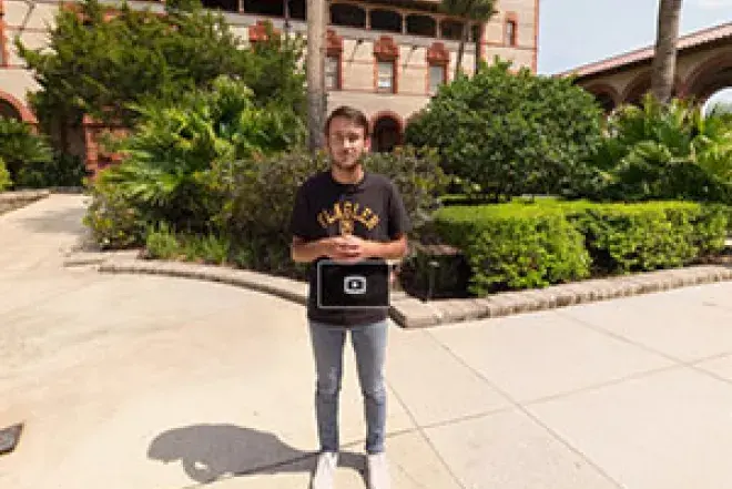 Flagler Student standing in the Ponce Hall Courtyard giving a tour