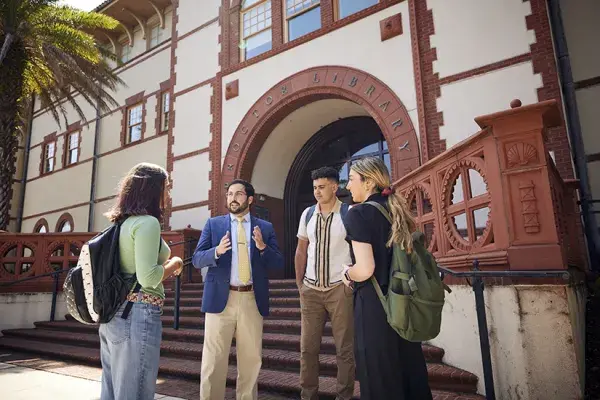 Students talking to Dr. Behl in front of the Proctor Library