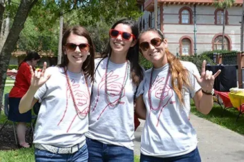 Three femals students wearing shirts reading "Deaf Awareness Day 2017" sign "I love you." 