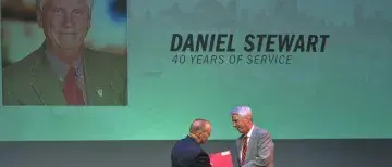 Daniel Stewart receives a handshake from President Joyner