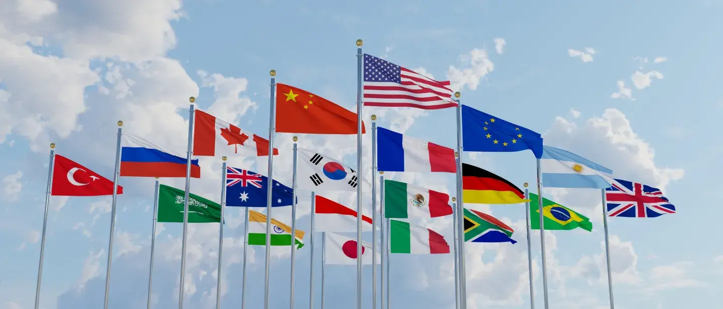 An array of international flags flying on a windy day 