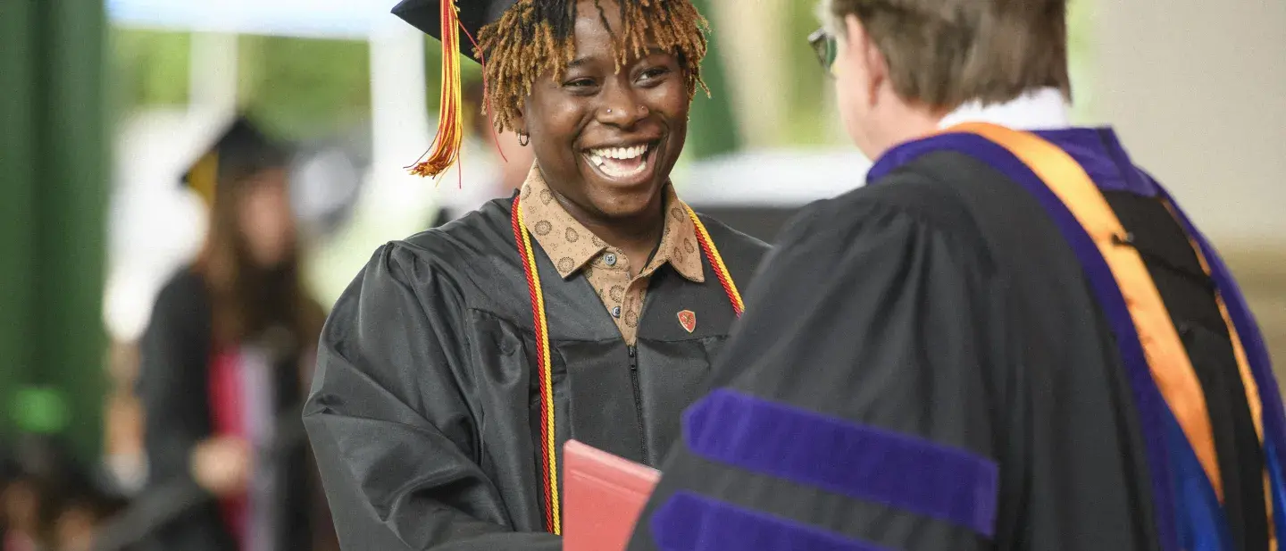 Student shaking President Delaney's hand at graduation