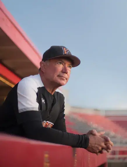 Coach Barnett leaning on a dugout