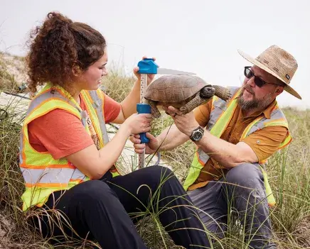 Ben Atkinson works with a student to measure a turtle