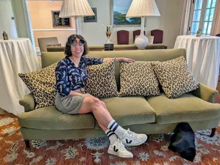 Lima posing on couch in the Alumni House