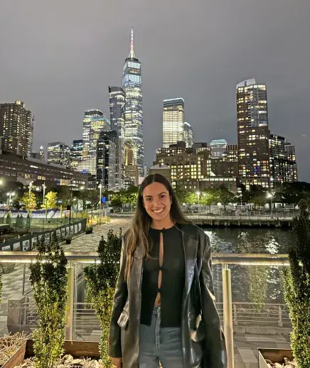 Fernanda with nighttime NYC skyline