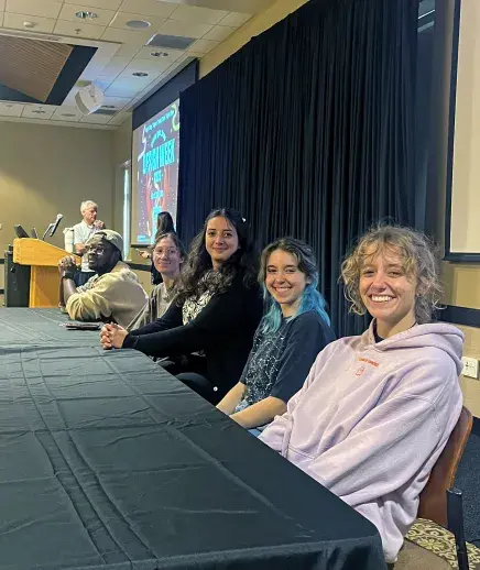 Rachel and GD peers at panel table for Deisgn Week