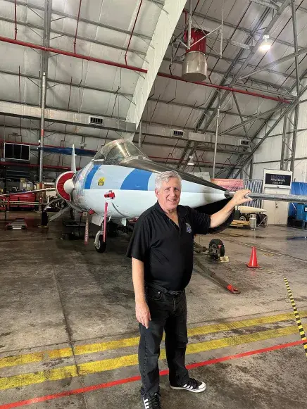 Tim Franta standing with an airplane in the background