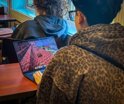 Studnent on his computer working in minecraft
