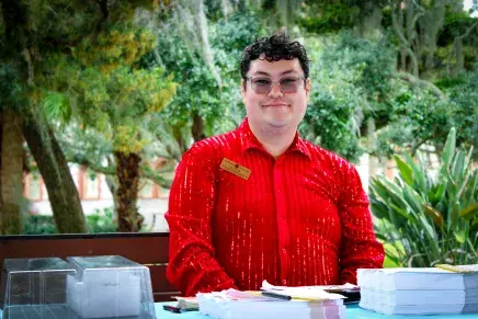 Interim Senior Assistant Director of Admissions Visitor Services Ben Tran welcomes students in a shiny red shirt
