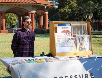 Alum Ryan Tempro stands at his booth as the owner of M.C. Pressure, a printing company.