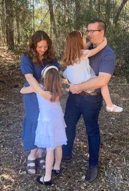 Carie and Zach Moore embrace their two children
