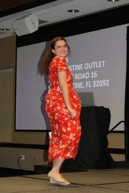 A student shows off her outfit at the education week fashion show