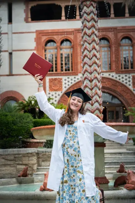 Christina Mark celebrating with diploma in hand