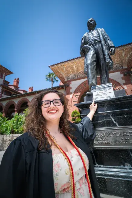 Abby Surber pointing to the Henry Flagler statue