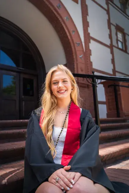 Ava Mantha sitting on the steps of the Proctor Library