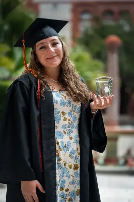 Christina Mark holding a beaker that she used as a biology student