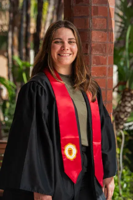 Alexis Gifford posing in her graduation regalia