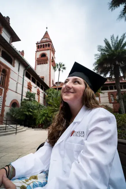 Christina Mark looking up at the sky with her Flagler branded white coat on