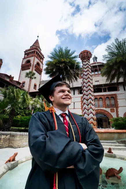 Tyler Newman staring off camera with a tower of The Ponce pictured behind him