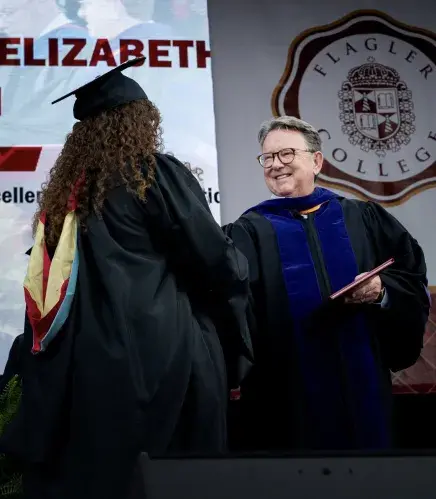 President Delaney presents a diploma to a graduating student