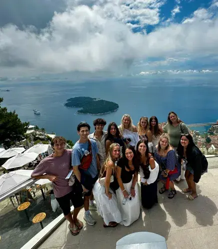 Students pose for a photo atop Mt. Srd
