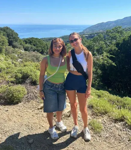 Two students pose atop a hill during their hike in Greece