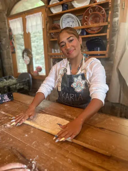 A student rolling out dough during an Ikarian cooking class