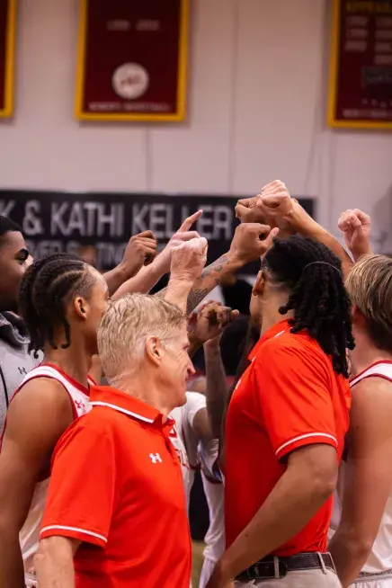 Men's Basketball Players with their hands in the center of circle