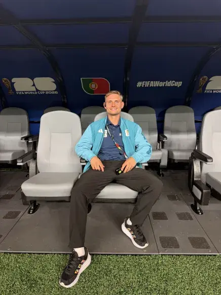 Ben Straw sitting in the bench dugout at the Houston FIFA World Cup stadium