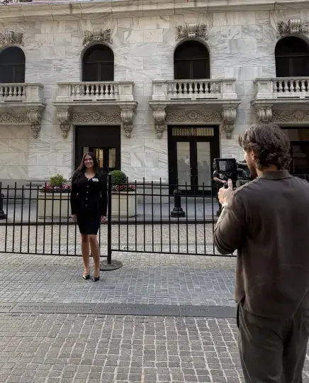 Brunatti having her picture taken outside of the New York Stock Exchange