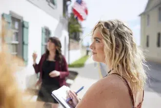 A Flagler College student takes notes during an outdoors lecture in the historic area of the city.