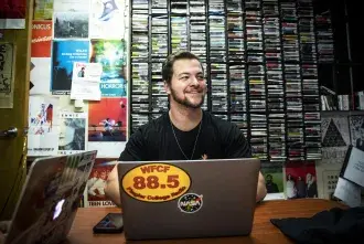 A Flagler College student works in the Flagler College radio station offices.