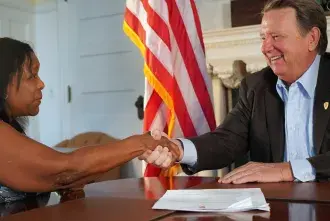 Flagler College President John Delaney shakes hands with Bermuda College's Phyllis Curtis-Tweed.