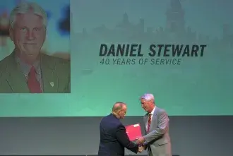 Daniel Stewart receives a handshake from President Joyner