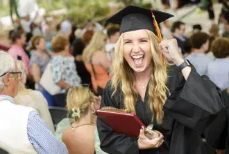 A Flagler college student cheers at graduation.