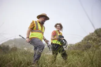 Dr. Ben Atkinson walking on the beach with a student