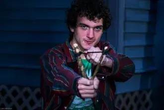 Main character "Benji" posing with slingshot loaded and aimed toward camera.