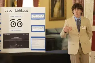 Student standing next to a business presentation