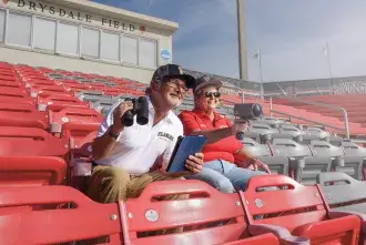 Jim Gilmore and Tracy Halcomb sitting in the bleachers at Drysdale field