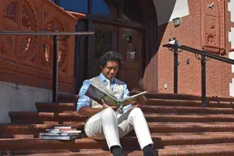 Chris Lowery in front of library reading book
