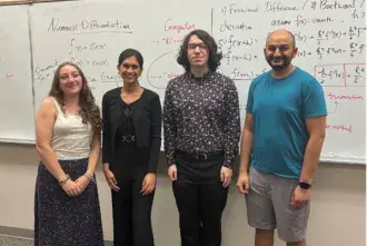 Christina Marks and others in front of white board with Math on it