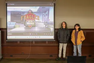 Two students stand at the front of class ready to present their film.