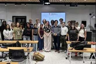 Flagler's Financial Investment Club stands at the front of a classroom for a picture