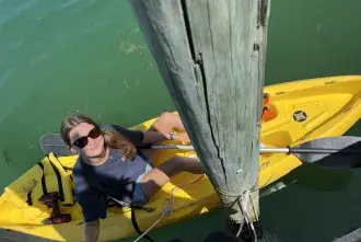 Zoe Kieffer sits in a kayak on the water while conducting her research