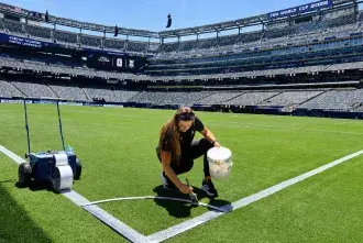 Brooke Rienecker painting the corner of a soccer field for the FIFA World Cup