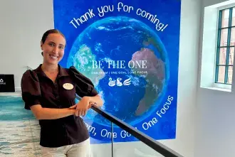 Addison Da Silva stands in front of a banner at the Swan and Dolphin resort