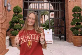 Zoe Zinnie standing in front of the Flagler main entrance