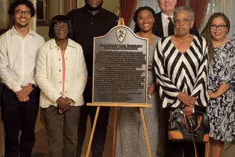 Dr. Michael Butler and Members of the Black Student Union stand with the commemorative plaque