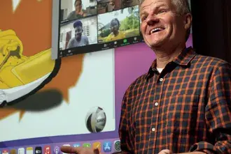 Professor of Art & Design Chris Smith standing in front of a large video screen